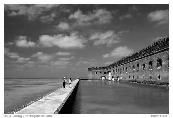 Tourists stroll on the seawall. Dry Tortugas National Park (black and white)
