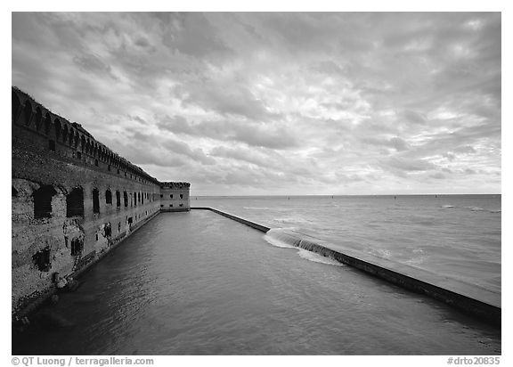 Fort Jefferson wall and moat with wave over seawall, cloudy weather. Dry Tortugas  National Park (black and white)