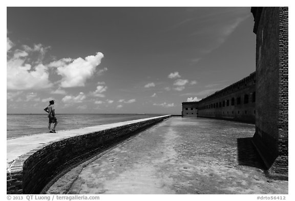 Park visitor looking, Fort Jefferson moat and seawall. Dry Tortugas National Park (black and white)