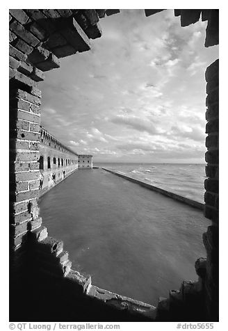 Fort Jefferson seawall and moat, framed by a crumpling embrasures, late afternoon. Dry Tortugas National Park (black and white)