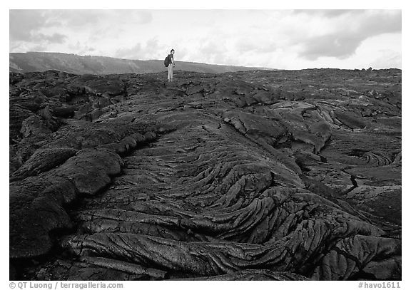 Hiker on hardened lava flow at the end of Chain of Craters road. Hawaii Volcanoes National Park (black and white)