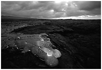 Flowing lava and rain clouds at dawn. Hawaii Volcanoes National Park ( black and white)