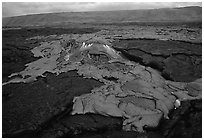 Live hot lava flows over hardened lava. Hawaii Volcanoes National Park, Hawaii, USA. (black and white)