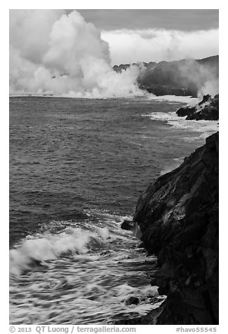 Coast with lava and clouds of smoke and steam produced by lava contact with ocean. Hawaii Volcanoes National Park (black and white)