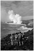 Hikers looking at molten lava and coastal volcanic steam cloud. Hawaii Volcanoes National Park ( black and white)