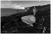 Photographer camping near lava ocean entry. Hawaii Volcanoes National Park, Hawaii, USA. (black and white)