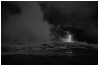 Lava runs down the cliff and goes into the sea at dawn. Hawaii Volcanoes National Park, Hawaii, USA. (black and white)