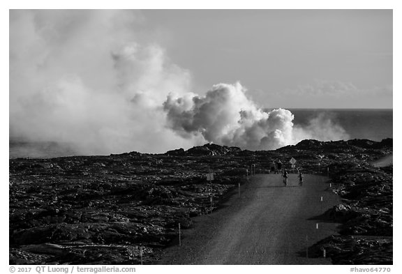 Byciclists and hikers approaching lava ocean entry on emergency road. Hawaii Volcanoes National Park (black and white)