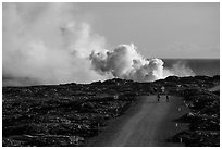 Byciclists and hikers approaching lava ocean entry on emergency road. Hawaii Volcanoes National Park ( black and white)