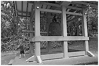 Boy ringing the buddhist bell, Byodo-In temple. Oahu island, Hawaii, USA ( black and white)