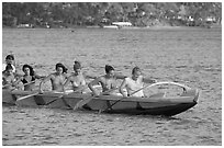 Outrigger canoe paddled by women in bikini, Maunalua Bay, late afternoon. Oahu island, Hawaii, USA (black and white)