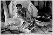 Fiji woman tying together leaves with her feet. Polynesian Cultural Center, Oahu island, Hawaii, USA ( black and white)
