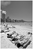 Young women on Waikiki Beach with skyline in the background. Waikiki, Honolulu, Oahu island, Hawaii, USA ( black and white)