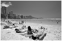 Young women sunning on Waikiki Beach. Waikiki, Honolulu, Oahu island, Hawaii, USA ( black and white)