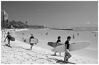 Men walking on Waikiki Beach with surfboards. Waikiki, Honolulu, Oahu island, Hawaii, USA ( black and white)