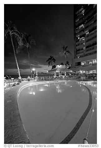 Swimming pool at night, with dance performance, Sheraton hotel. Waikiki, Honolulu, Oahu island, Hawaii, USA (black and white)