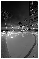 Swimming pool at night, with dance performance, Sheraton hotel. Waikiki, Honolulu, Oahu island, Hawaii, USA ( black and white)