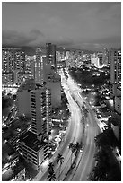 Boulevard and high rise buildings at dusk. Waikiki, Honolulu, Oahu island, Hawaii, USA (black and white)