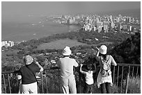 Tourists look at Waikidi from the  Diamond Head crater, early morning. Oahu island, Hawaii, USA (black and white)