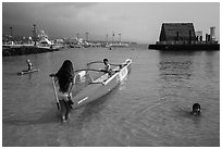 Girls, outrigger canoe, and Kamakahonu heiau, Kailua-Kona. Hawaii, USA ( black and white)
