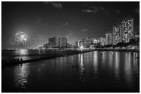 Watching fireworks from seawall, Kuhio Beach, Waikiki. Waikiki, Honolulu, Oahu island, Hawaii, USA ( black and white)