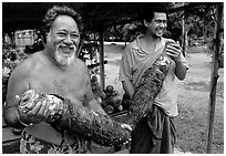 Islanders holding Taro roots in Iliili. Tutuila, American Samoa (black and white)