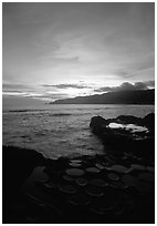 Water-filled  grinding stones holes (foaga) and Leone Bay at sunset. Tutuila, American Samoa (black and white)