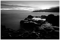 Grinding stones holes (foaga) filled with water at dusk, Leone Bay. Tutuila, American Samoa (black and white)