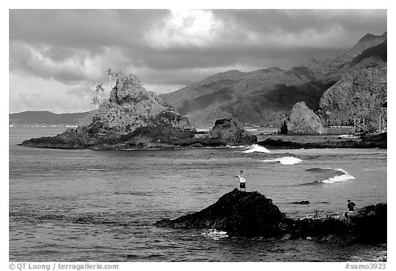 Fishermen on the rocky shore near Maa Kamela. Tutuila, American Samoa (black and white)