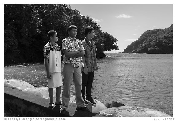 Samoan boys standing on seawall, Fagasa. Tutuila, American Samoa (black and white)