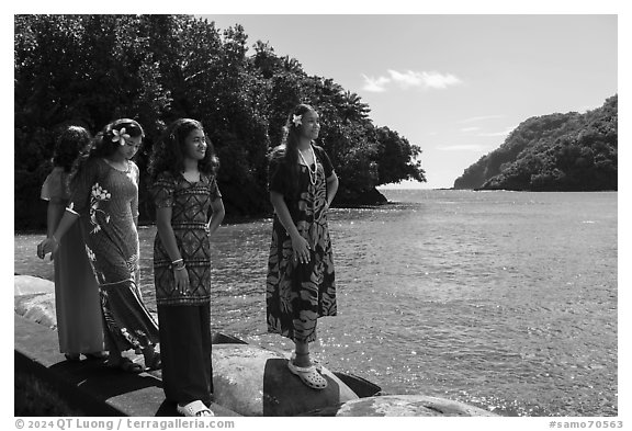 Samoan girls standing on seawall in Fagasa Bay. Tutuila, American Samoa (black and white)