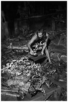 Man taking out foods prepared in Umu earth oven, Tisa Barefoot Bar. Tutuila, American Samoa ( black and white)