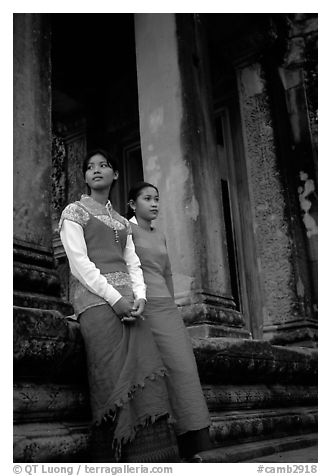 Elegant young women near temple entrance. Angkor, Cambodia (black and white)
