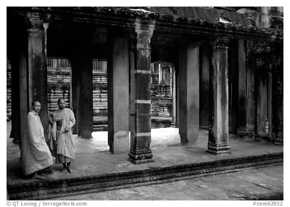 Two Buddhist monks in dark temple, Angkor Wat. Angkor, Cambodia (black and white)