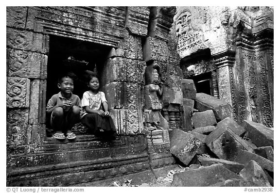 Boy and girl sit at window in Ta Prom. Angkor, Cambodia (black and white)