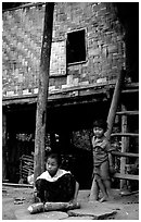 Children near stilt house of a small hamlet. Mekong river, Laos ( black and white)