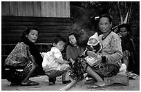 Group of women and children in a small hamlet. Mekong river, Laos (black and white)