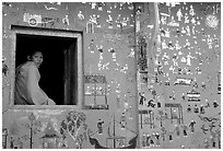 Buddhist novice monk sits at window of shrine, Wat Xieng Thong. Luang Prabang, Laos ( black and white)