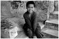 Boy sells incence sticks at the entrance of a shrine, Pak Ou. Laos ( black and white)