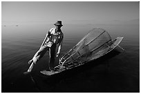 Intha fisherman on duggout with net. Inle Lake, Myanmar (black and white)