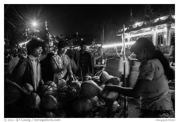 Customers waiting for coconuts to be cut on the street. Yangon, Myanmar (black and white)