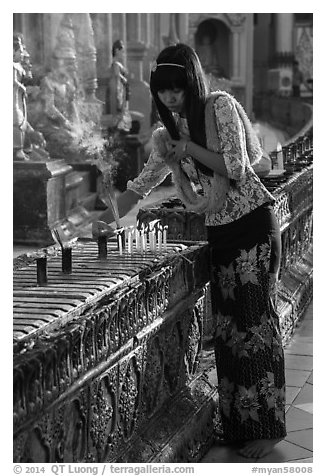Woman lighting candles, Shwedagon Pagoda. Yangon, Myanmar (black and white)