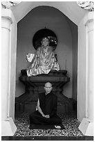 Monk meditating in alcove with Buddha statue, Shwedagon Pagoda. Yangon, Myanmar ( black and white)