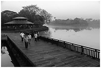 People walking for exercise at dawn, Kandawgyi Lake Park. Yangon, Myanmar ( black and white)
