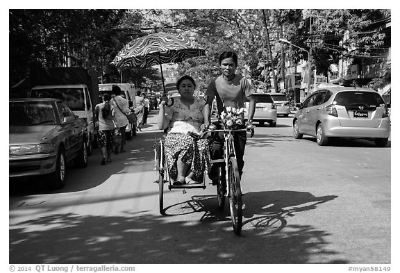 Woman holding unbrella against sun while riding Trishaw. Yangon, Myanmar (black and white)