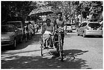 Woman holding unbrella against sun while riding Trishaw. Yangon, Myanmar ( black and white)