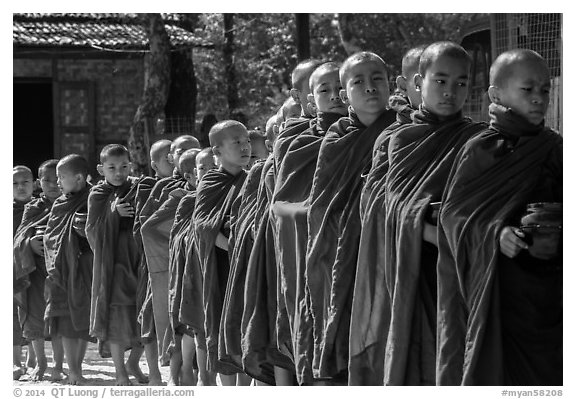 Novices lining up with alms bowls, Nyaung U. Bagan, Myanmar (black and white)
