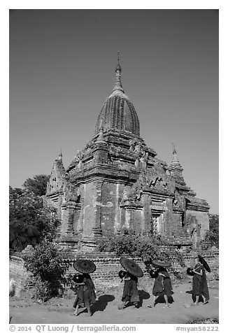 Four novices walk next to temple. Bagan, Myanmar (black and white)