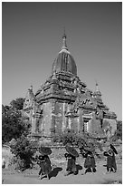 Four novices walk next to temple. Bagan, Myanmar ( black and white)