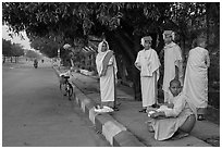 Nuns waiting for ride on sidewalk. Mandalay, Myanmar ( black and white)